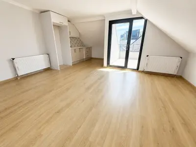 Daire 2 üst kat salonu: mutfak nişi ve terasa açılan siyah doğramalı kapı